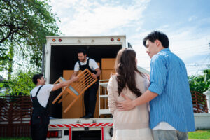 Asian Couple Check While Unloading Boxes And Furniture From A Pickup Truck To A New House With Service Cargo Two Men Movers Worker In Uniform Lifting Boxes. Concept Of Home Moving And Delivery. - estate cleanout Genesis Removal